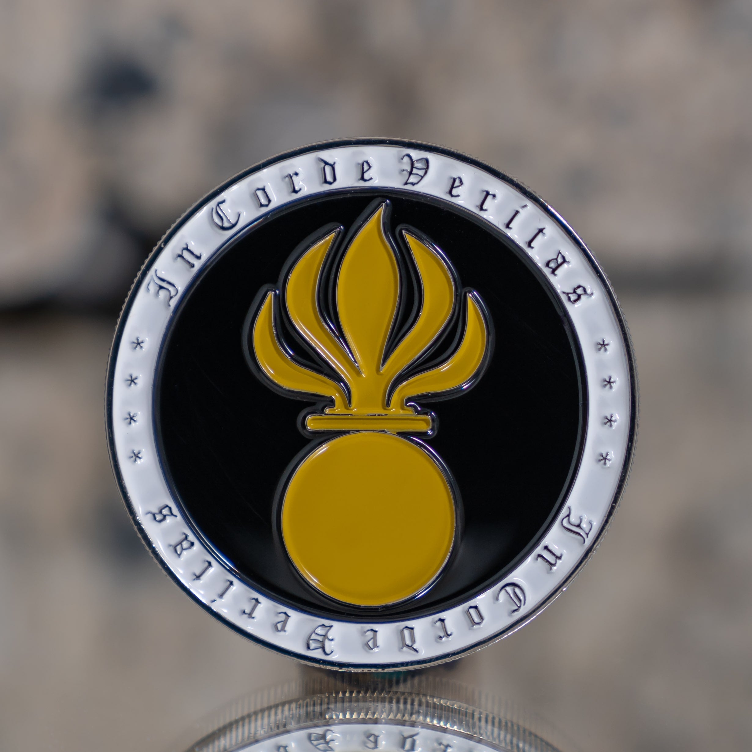 Silberne Army Coin Ch Münze mit gelbem Emblem und lateinischer Inschrift auf schwarzem Hintergrund.